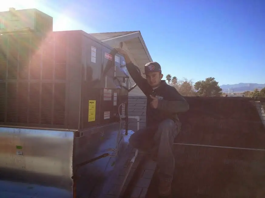 HVAC technician performing Boiler Repair on a rooftop unit in Aliquippa